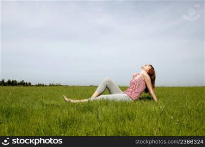 Young woman relaxing on a beautiful green meadow