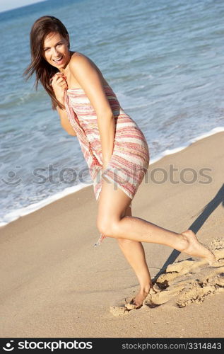 Young Woman Relaxing On Beach Wearing Wrap