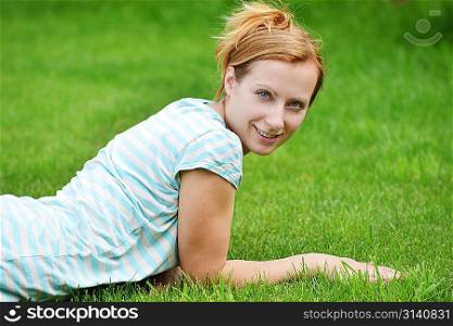 young woman relaxing on green graas