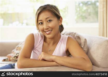 Young Woman Relaxing On Sofa At Home