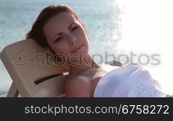 young woman relaxing on the beach at sunset