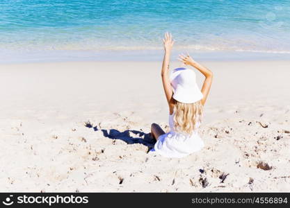 Young woman relaxing on the beach. Portrait of young pretty woman cheering and relaxing on sandy beach