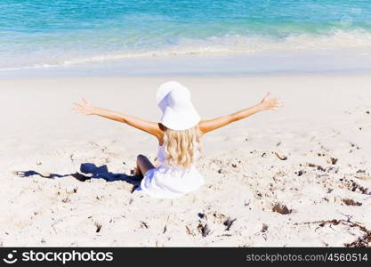 Young woman relaxing on the beach. Portrait of young pretty woman cheering and relaxing on sandy beach