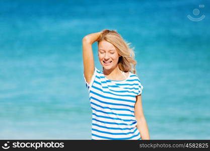 Young woman relaxing on the beach. Portrait of young pretty woman cheering and relaxing on sandy beach