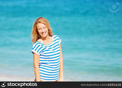 Young woman relaxing on the beach. Portrait of young pretty woman cheering and relaxing on sandy beach