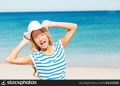 Young woman relaxing on the beach. Portrait of young pretty woman cheering and relaxing on sandy beach