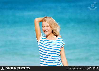 Young woman relaxing on the beach. Portrait of young pretty woman cheering and relaxing on sandy beach