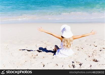 Young woman relaxing on the beach. Portrait of young pretty woman cheering and relaxing on sandy beach
