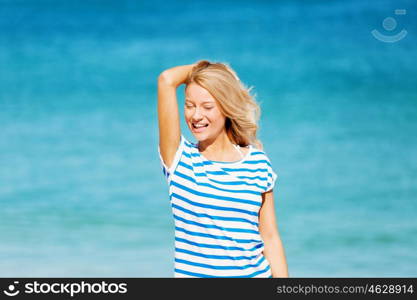 Young woman relaxing on the beach. Portrait of young pretty woman cheering and relaxing on sandy beach