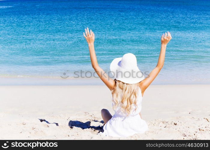 Young woman relaxing on the beach. Portrait of young pretty woman cheering and relaxing on sandy beach