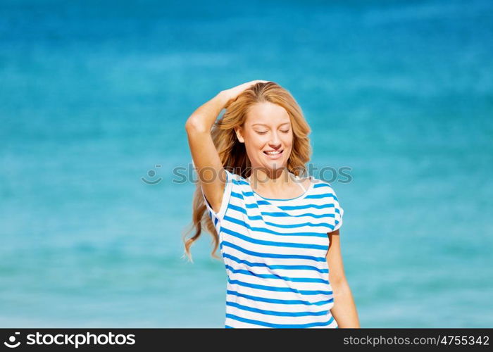 Young woman relaxing on the beach. Portrait of young pretty woman cheering and relaxing on sandy beach