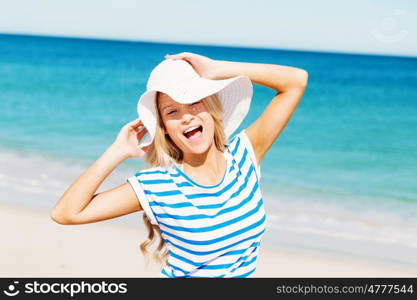 Young woman relaxing on the beach. Portrait of young pretty woman cheering and relaxing on sandy beach