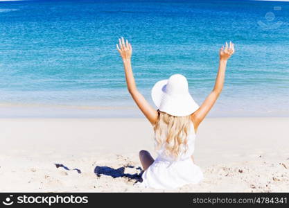 Young woman relaxing on the beach. Portrait of young pretty woman cheering and relaxing on sandy beach