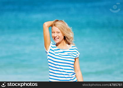 Young woman relaxing on the beach. Portrait of young pretty woman cheering and relaxing on sandy beach