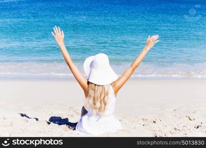 Young woman relaxing on the beach. Portrait of young pretty woman cheering and relaxing on sandy beach