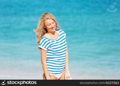 Young woman relaxing on the beach. Portrait of young pretty woman cheering and relaxing on sandy beach