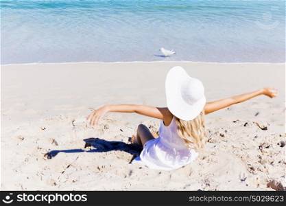 Young woman relaxing on the beach. Portrait of young pretty woman cheering and relaxing on sandy beach