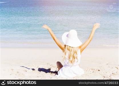 Young woman relaxing on the beach. Portrait of young pretty woman cheering on sandy beach