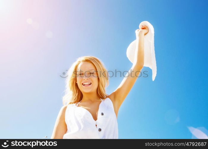 Young woman relaxing on the beach. Portrait of young pretty woman cheering on sandy beach