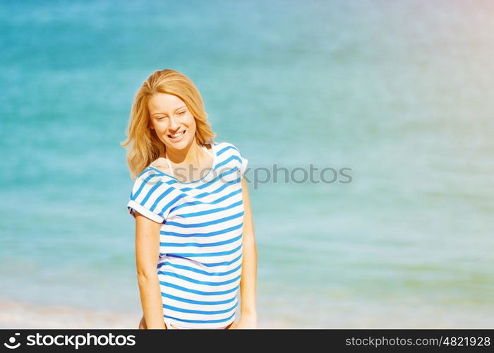 Young woman relaxing on the beach. Portrait of young pretty woman cheering on sandy beach