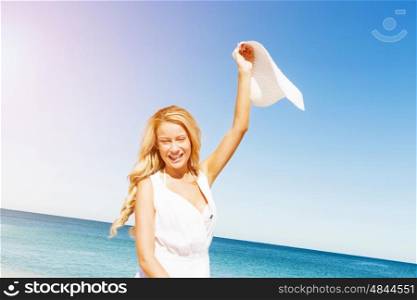 Young woman relaxing on the beach. Portrait of young pretty woman cheering on sandy beach