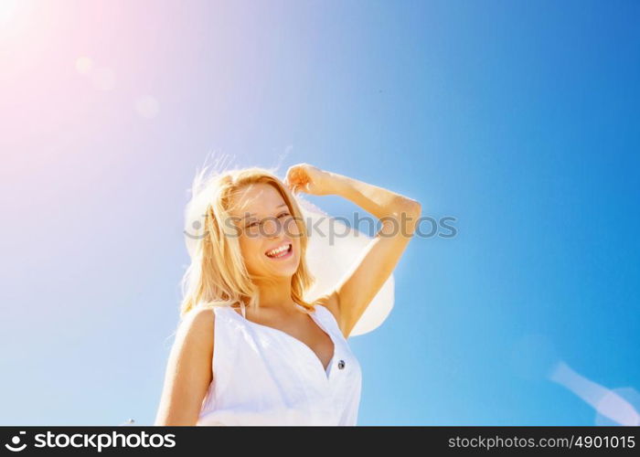 Young woman relaxing on the beach. Portrait of young pretty woman cheering on sandy beach