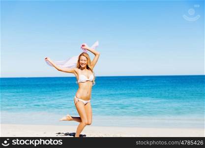 Young woman relaxing on the beach. Portrait of young pretty woman in white bikini relaxing on sandy beach