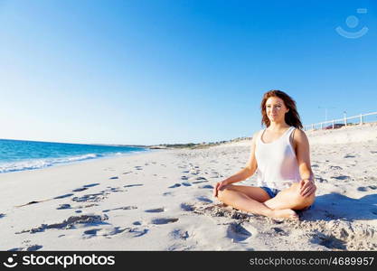 Young woman relaxing on the beach. Portrait of young pretty woman relaxing and meditating on sandy beach