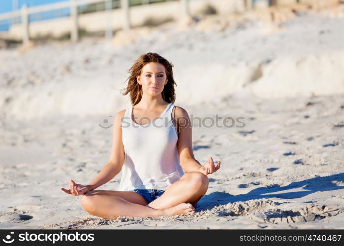 Young woman relaxing on the beach. Portrait of young pretty woman relaxing and meditating on sandy beach