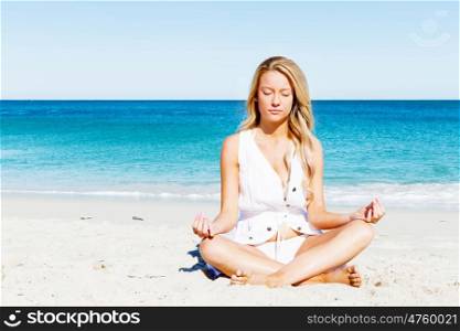 Young woman relaxing on the beach. Portrait of young pretty woman relaxing and meditating on sandy beach