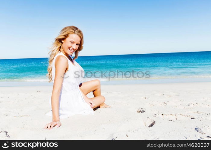 Young woman relaxing on the beach. Portrait of young pretty woman relaxing on sandy beach