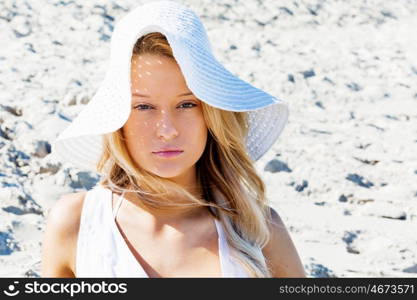 Young woman relaxing on the beach. Portrait of young pretty woman relaxing on sandy beach