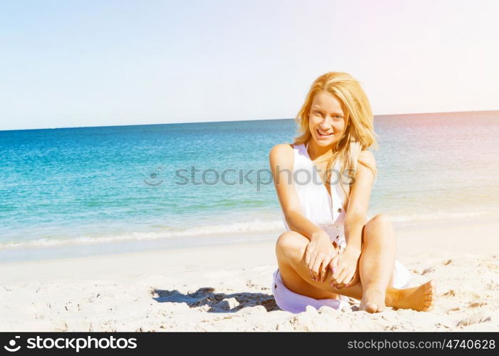 Young woman relaxing on the beach. Portrait of young pretty woman relaxing on sandy beach