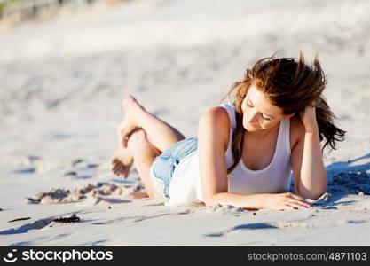 Young woman relaxing on the beach. Portrait of young pretty woman relaxing on sandy beach