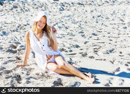 Young woman relaxing on the beach. Portrait of young pretty woman relaxing on sandy beach