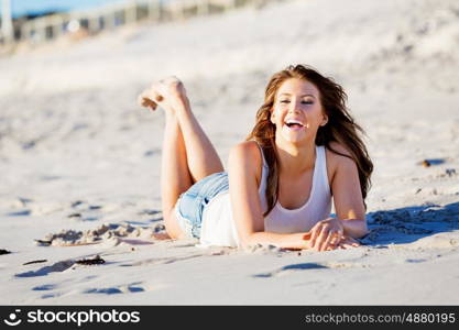 Young woman relaxing on the beach. Portrait of young pretty woman relaxing on sandy beach