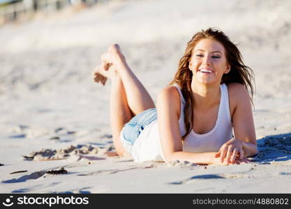 Young woman relaxing on the beach. Portrait of young pretty woman relaxing on sandy beach