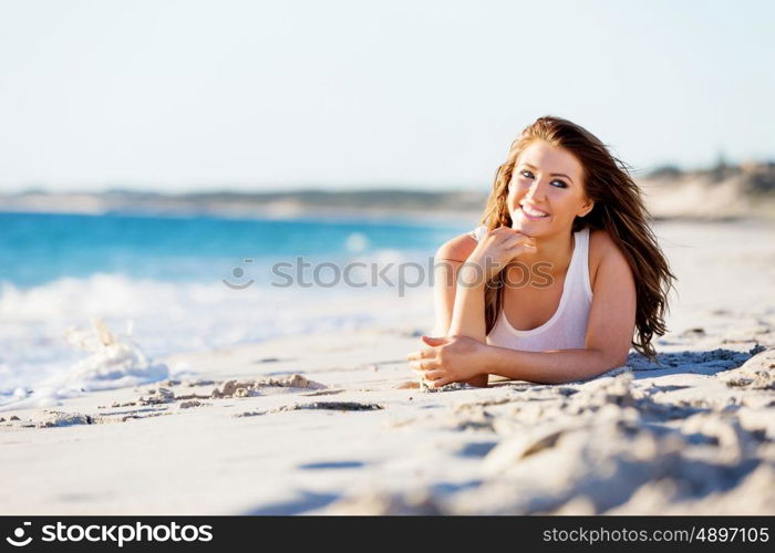 Young woman relaxing on the beach. Portrait of young pretty woman relaxing on sandy beach