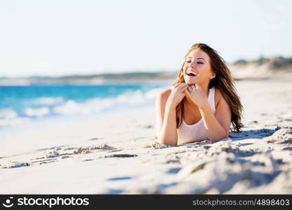 Young woman relaxing on the beach. Portrait of young pretty woman relaxing on sandy beach