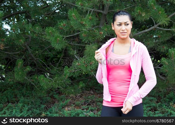 Young woman removing her jacket before a workout