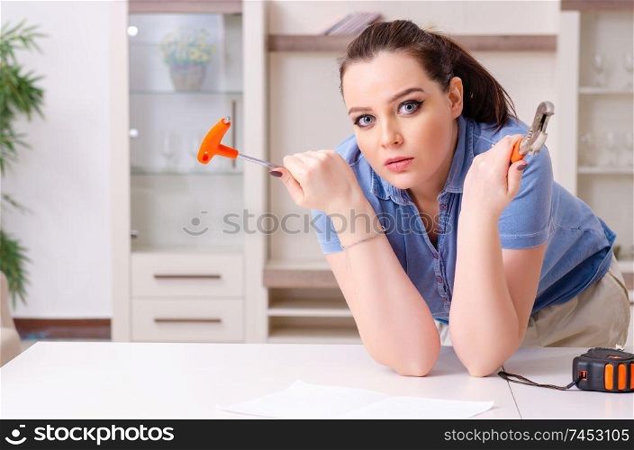 Young woman repairing chair at home 