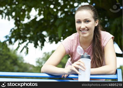 Young Woman Resting On Park Bench During Exercise