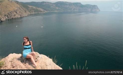 young woman Resting on the cliff near the Black Sea, Bay of Balaclava, Crimea