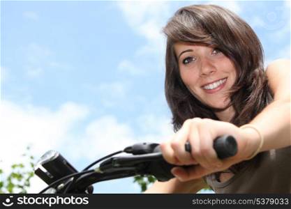 Young woman riding a bike in the summertime