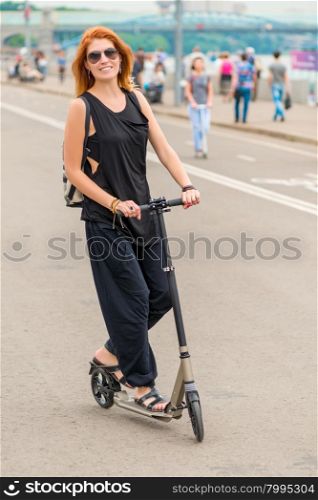 young woman riding a scooter on the road