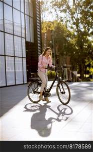 Young woman riding an electric bicycle in urban environment