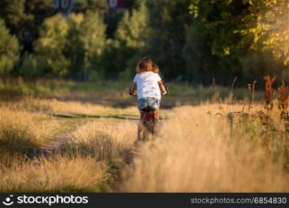 Young woman riding bicycle at meadow on dirt road