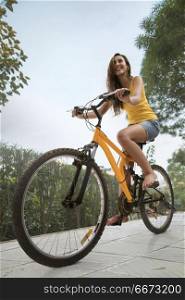 Young woman riding bicycle in park