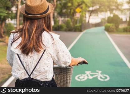 Young woman riding bicycle on bike lane in the park