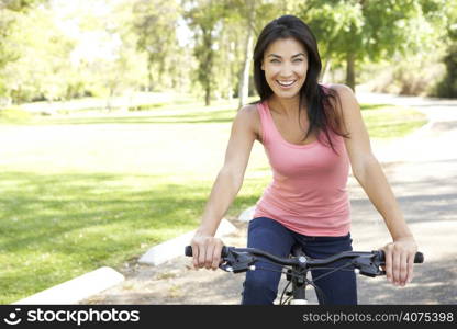 Young Woman Riding Bike In Park